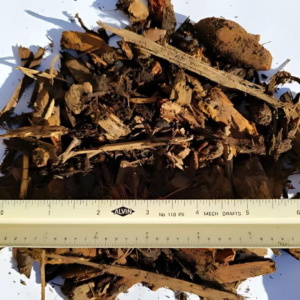 Close-up of "Walk-On Bark" with mixed wood chips, sticks, and bark pieces, measured with a ruler for size reference.