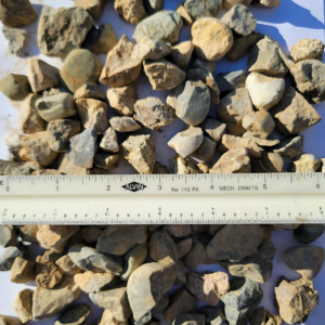 Crushed rock pieces displayed with a ruler for scale.