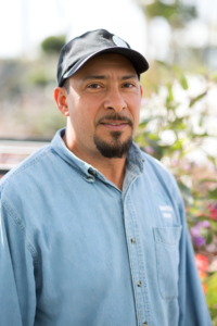Ruben Hernandez, Retail Sales representative at Green Hills Nursery, wearing a denim shirt and a black cap.